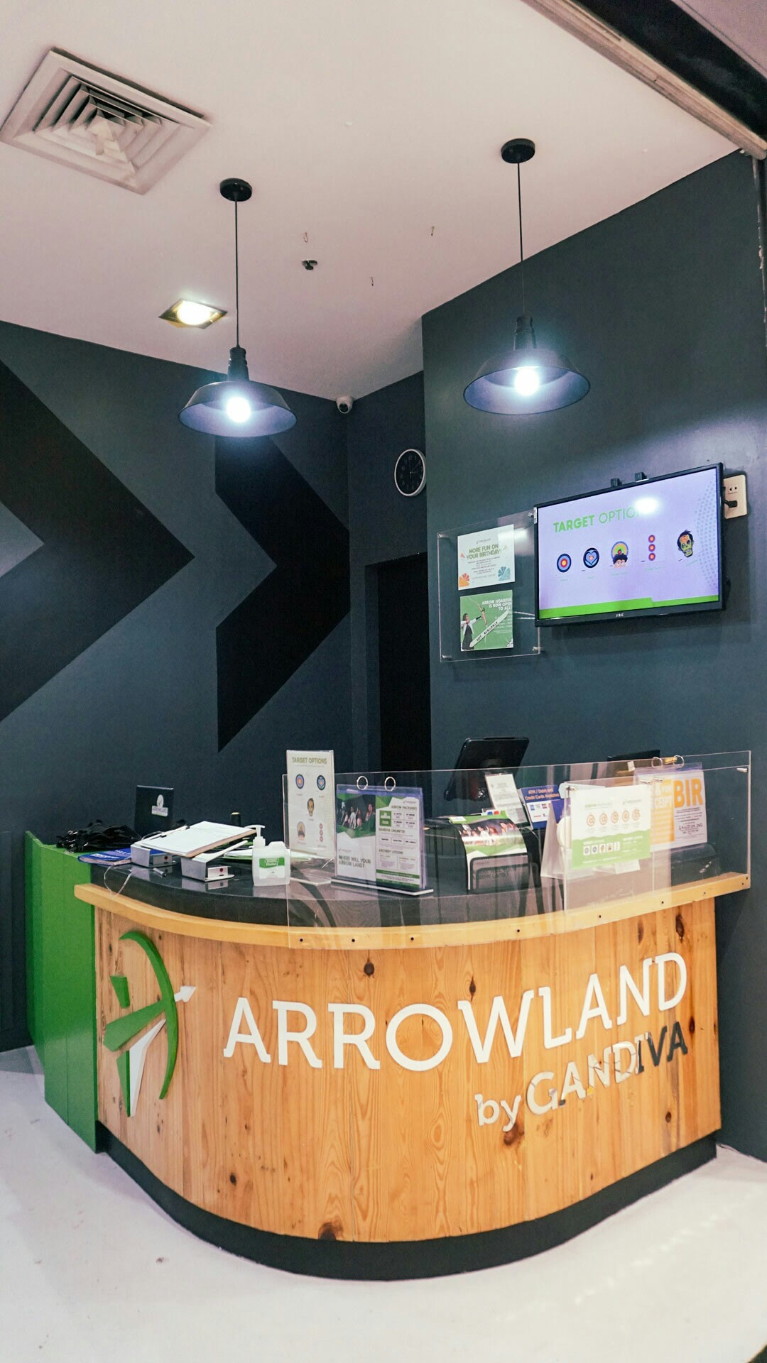 Arrowland reception desk with wooden counter and Arrowland by Gandiva logo